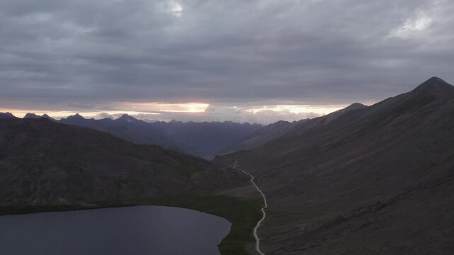 Sheosar Lake with a dirt road leading through Deosai Plains toward distant Nanga Parbat. Gilgit-Baltistan, Pakistan
