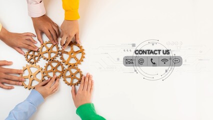 A creative workspace scene showing diverse hands arranging wooden gears on a white surface, symbolizing teamwork and communication for business success. Raster