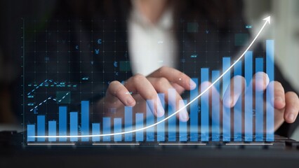 A business professional analyzes digital graphs and charts on a laptop, showcasing growth in a modern office environment. Financial insights drive data-driven decisions. Copula