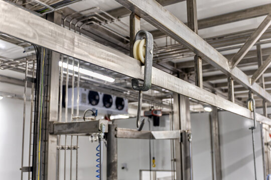 stainless steel overhead conveyor system with a hook and pulley, used in food processing facilities such as meat packing plants