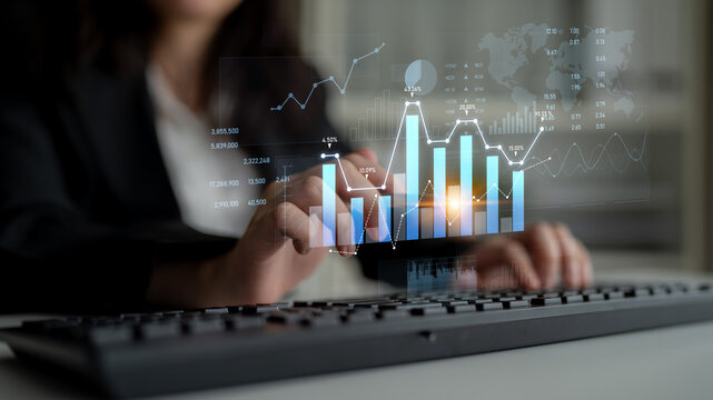 A business professional engages with data analysis on a keyboard, surrounded by digital graphs and charts, representing financial trends and metrics in an office backdrop. Scalp
