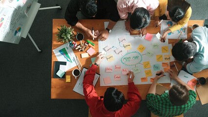 Group of business people writing sticky note and making mind map to brainstorming marketing idea at...