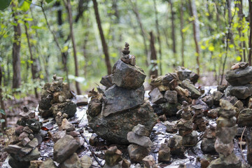 Calm zen rock cairn showing spiritual balance in green forest. peaceful stack of stone representing harmony and serenity in nature, meditative outdoor concept