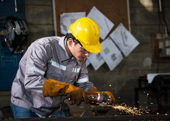 Factory welder worker in protective gear uses grinder on metal beam in industrial workshop, sparks fly with focus and strength, skilled craft under hard hat and gloves
