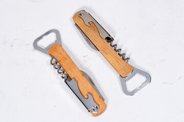 wooden bottle opener, corcscrew with switchblade on white background, commercial photo concept
