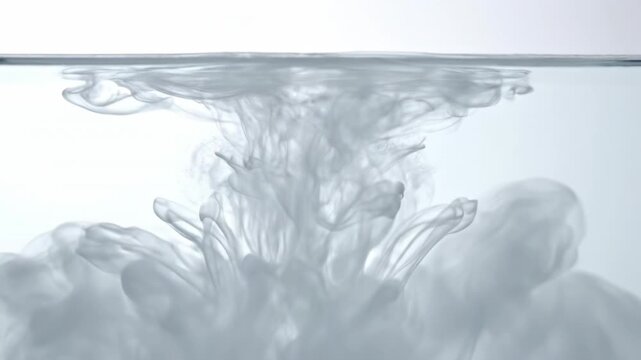 Slow motion detail of thick white translucent fluid dissolving into clear water demonstrating a gradual loss of opacity and becoming completely transparent liquid blank, chemical, high speed