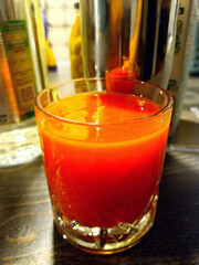 a bloody Mary cocktail in a glass against the background of a bar on a wooden table. taken vertically, in close-up with natural lighting. life style