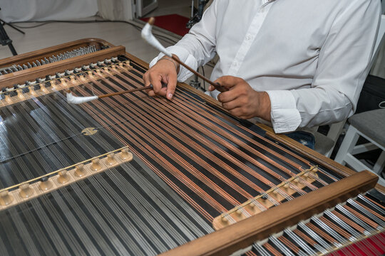 a person playing a cimbalom, also known as a hammered dulcimer. It is a string instrument popular in Romania,2025