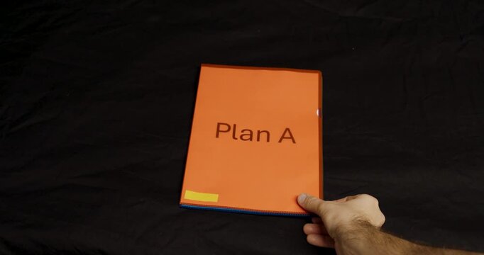Three folders labeled Plan A, Plan B, and Plan C are laid out in a row on a black surface, symbolizing organization, planning, and decision strategy.
