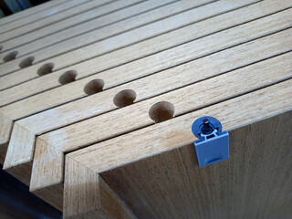 drilled holes for shelf holders in close-up view in furniture production on a wooden background