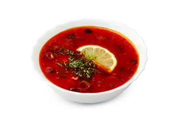 Delicious tomato soup with lemon slice and herbs served in a white bowl