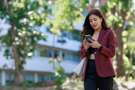 Young woman walking outdoors using smartphone and smartwatch
