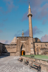 Historic Seljuk Hunat Mosque, Hunat Camii, with its towering minaret and ornate entrance, under a blue sky in Kayseri, Turkey