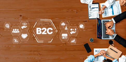 Overview of a modern B2C marketing strategy session with professionals working on laptops, discussing analytics, and using digital icons to foster collaboration in a business setting. Trope