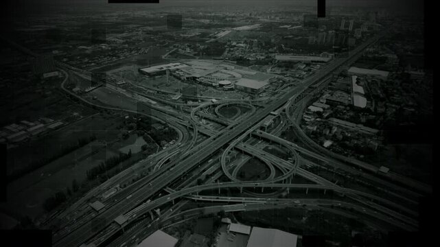 Aerial surveillance, military reconnaissance view of a complex highway interchange with HUD targeting graphics, creating a cinematic spy-drone atmosphere and intelligence-operation mood