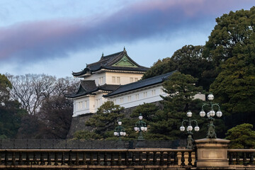 Imperial Palace in Tokyo, Japan. Bridge over the moat is in the foreground; clouds and morning sky above. 
