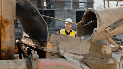 A construction worker is operating heavy machinery on a building site