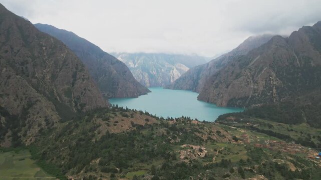 Above Shey Phoksundo Lake, a drone captures vivid turquoise water bordered by sheer Dolpa cliffs and silent Himalayan wilderness. This rare aerial view shows Nepal&rsquo;s untouched natural wonder.