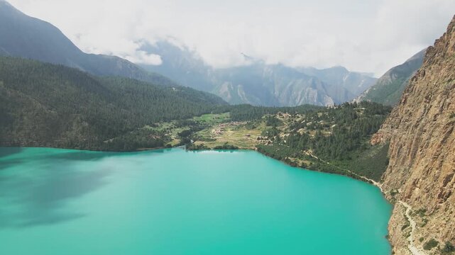 A drone floats over Shey Phoksundo Lake, revealing turquoise depth against Dolpa&rsquo;s vertical cliffs and vast Himalayan silence. This aerial scene highlights Nepal&rsquo;s untouched wilderness at its purest.