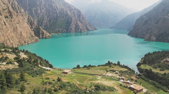A drone floats over Shey Phoksundo Lake, revealing turquoise depth against Dolpa&rsquo;s vertical cliffs and vast Himalayan silence. This aerial scene highlights Nepal&rsquo;s untouched wilderness at its purest.