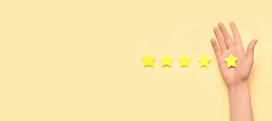 Female hand and five stars on color background. Customer experience concept
