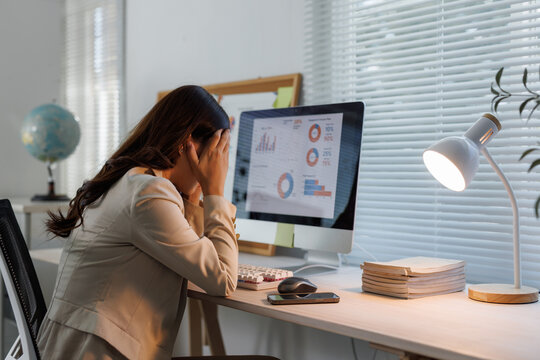 Stressed businesswoman suffering headache working late at office desk - Powered by Adobe