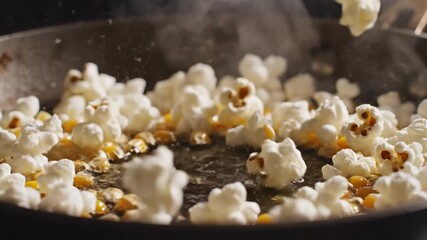 Close-up of yellow corn kernels rapidly popping into fluffy white popcorn in a hot skillet with steam rising. - Powered by Adobe