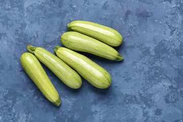 Many fresh green zucchini on blue background
