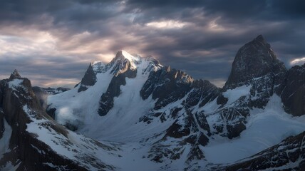 A dramatic view of snow capped mountains under a cloudy and stormy sky view