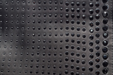 Black fabric with decorative black rhinestones in a repeating pattern