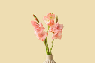 Vase with bouquet of beautiful gladiolus flowers on beige background