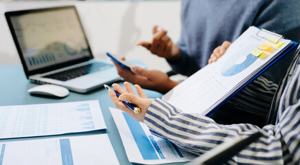 Businessman and team analyzing financial statement Finance task. with smart phone and laptop and ...