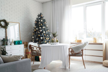 Interior of dining room with table, drawers and Christmas tree