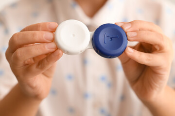 Little girl with contact lens case in bathroom, closeup
