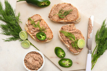 Board with toasts, tasty pate, dill, jalapeno pepper and knife on light background