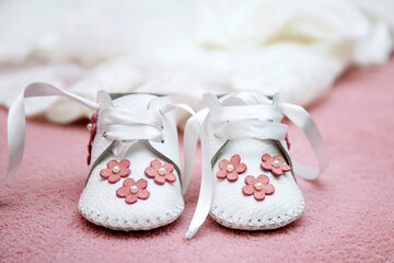 Newborn baby shoes on pink blanket