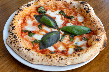 Sour dough pizza flat bread with mozzarella cheese, tomatoes and basil leaves Margarita, Napels street food, Italy