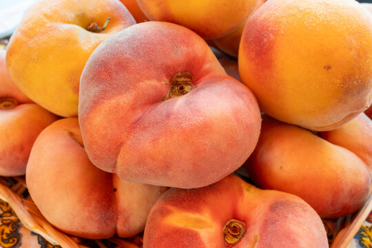 Fresh ripe sweet yellow and flat peaches Prunus persica or doughnut peach or Saturn peach