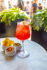 Drinks in Milan, tasting of traditional italian cocktail with sparkling wine Prosecco, orange, campari bitter liquor in bar with view on Duomo Milan, Italy