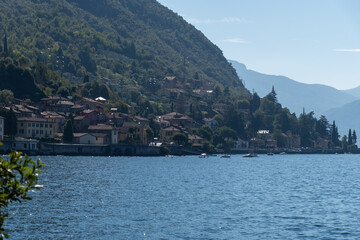 Fototapeta premium Views of lake Como with blue water, alpine mountains, beautiful villages, parks and villas, travel destination in North of Italy