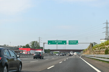 Driving car on highway near Milan, road signs, directions, traffic jam, North of Italy, tourists destination in Lombardy