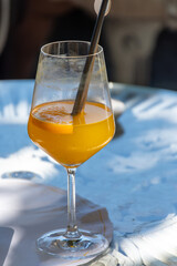 Drinks on Como lake near Milan, tasting of traditional italian cocktail with sparkling wine Prosecco, orange, aperol or campari bitter liquor in bar with view on waters of Como lake, Italy