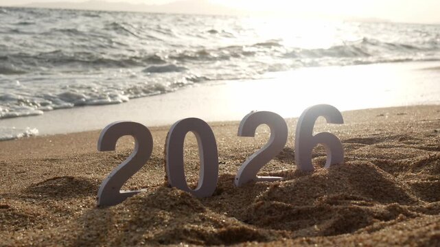 number 2026 for new year sign on summer beach at sunset time, with ripple sea wave and beautiful nature at background, 2026 New Year celebration concept