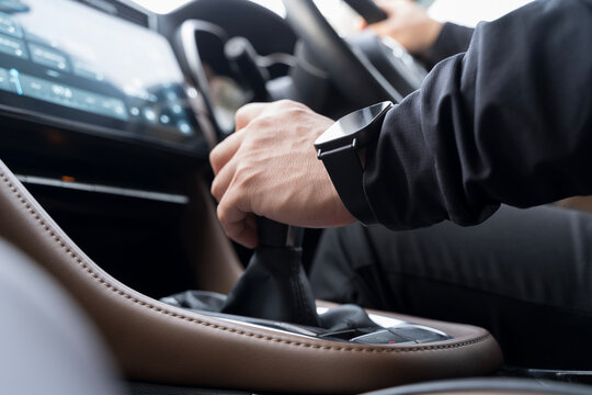 Close-up of driver hand shifting gear in modern car interior, showing control, movement, and driving action - Powered by Adobe