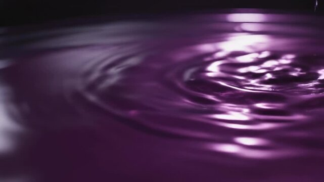 Slow motion cinematic close-up of subtle ripple patterns spreading continuously across a deep purple liquid surface caused by low-frequency vibration mystery, surface, energy