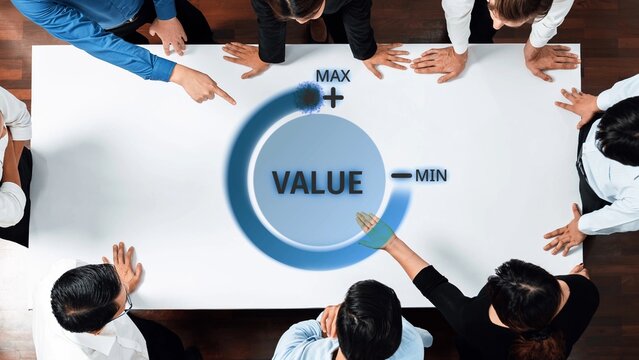 Aerial view of a business team gathered around a table, analyzing value metrics represented by a circular gauge, highlighting maximum and minimum value indicators in a collaborative setting. Raster