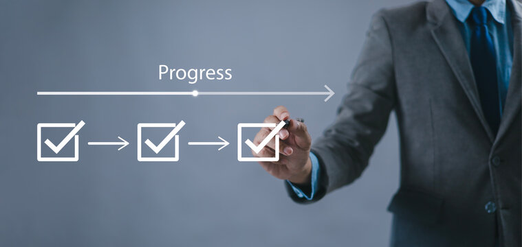 Businessman using check mark on checklist with progressive loading status to remind work in progress for project development management and idea tracking.