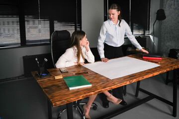 Discussion between two colleagues at a modern office desk in the afternoon