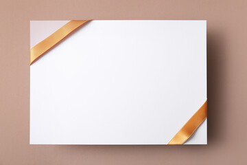 Blank paper sheet with beautiful golden ribbon on color background