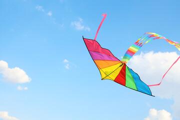 Colorful kite flying in blue sky on sunny day